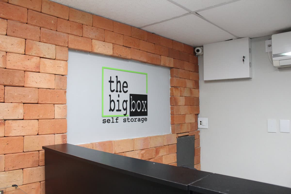 Recepção da The Big Box com a marca na parede de tijolos