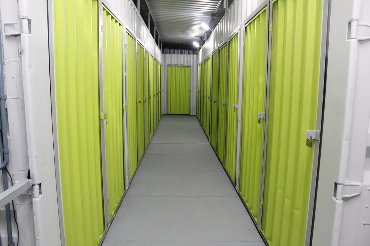 Corredor de boxes da The Big Box com portas verdes